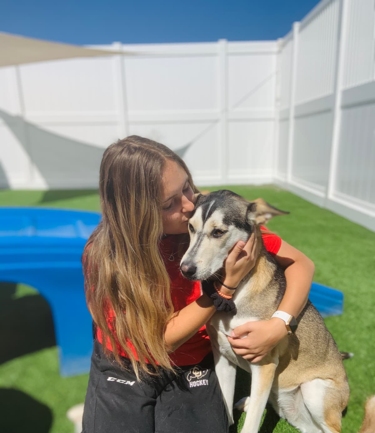 Stephanie hugging a dog in the backyard